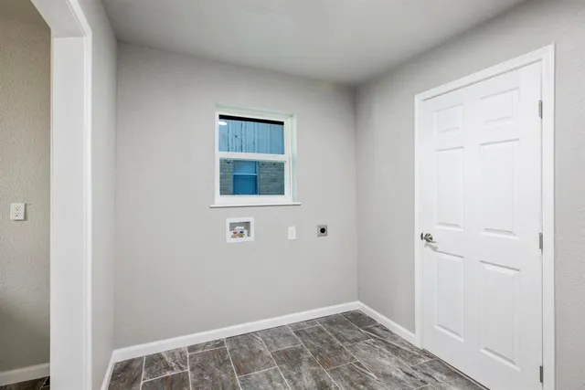 a view of an empty room with closet and a window