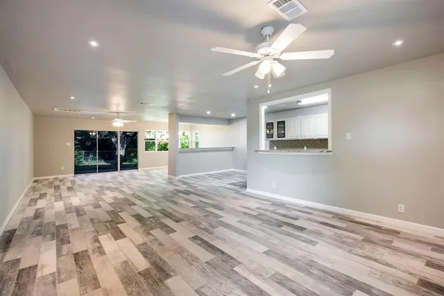 a view of an empty room and kitchen view