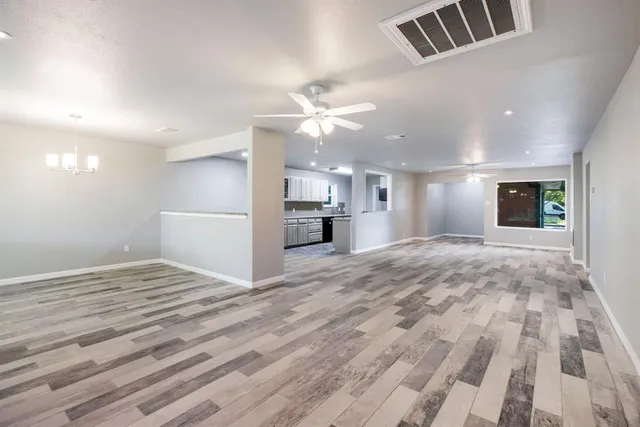 a view of an empty room and kitchen view