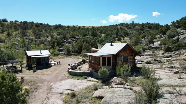 an aerial view of a house with a yard and mountain view