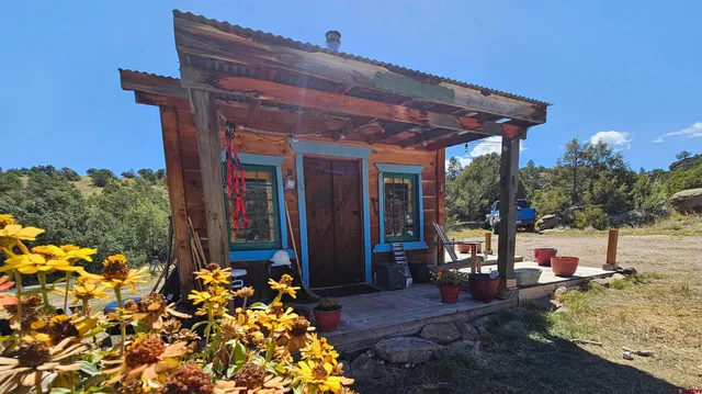 a patio with table and chairs and potted plants