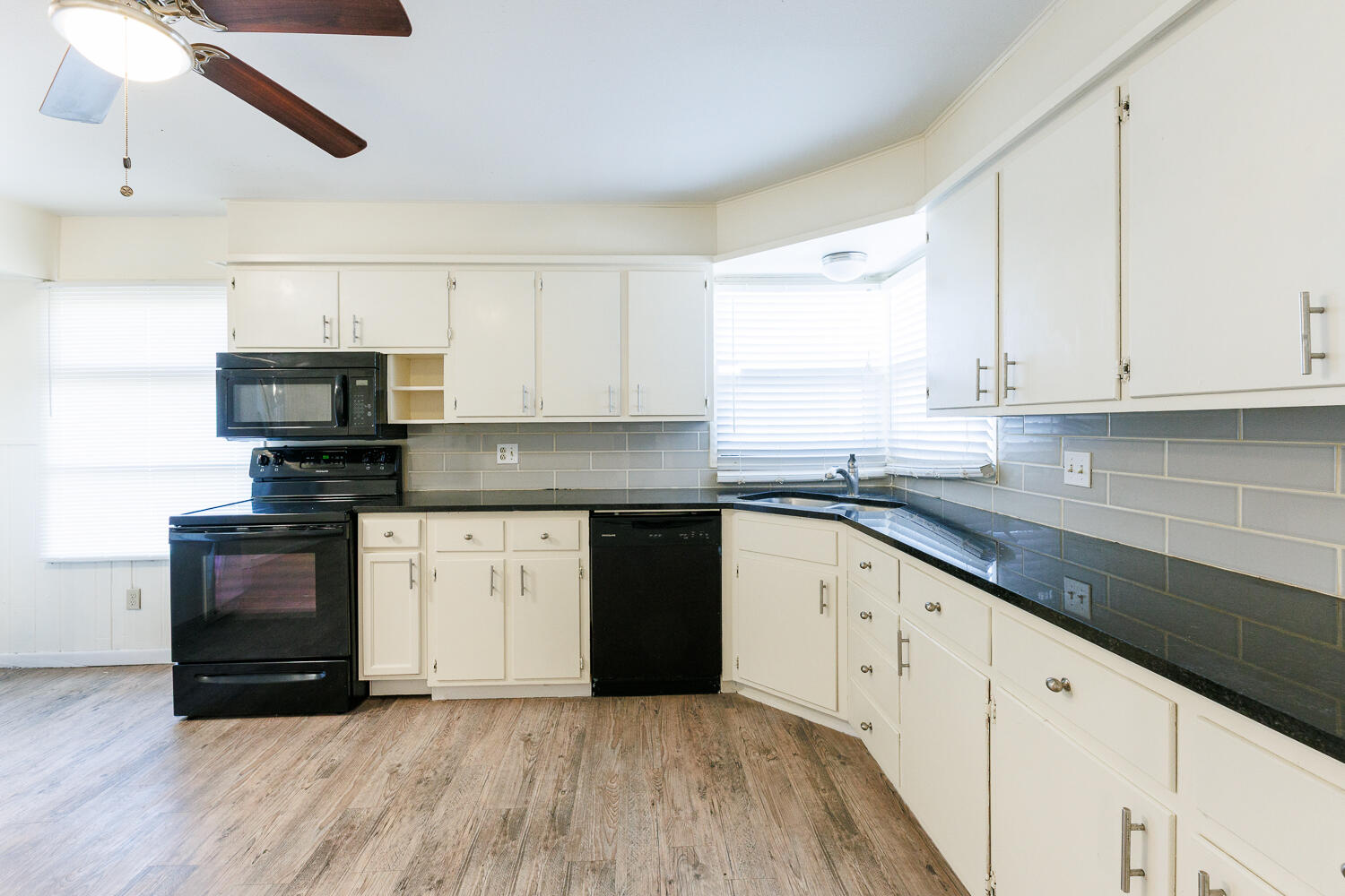 4319 40th Street Lubbock, TX 79413 - Photo 12 of 38 a kitchen with granite countertop a stove a sink and a microwave