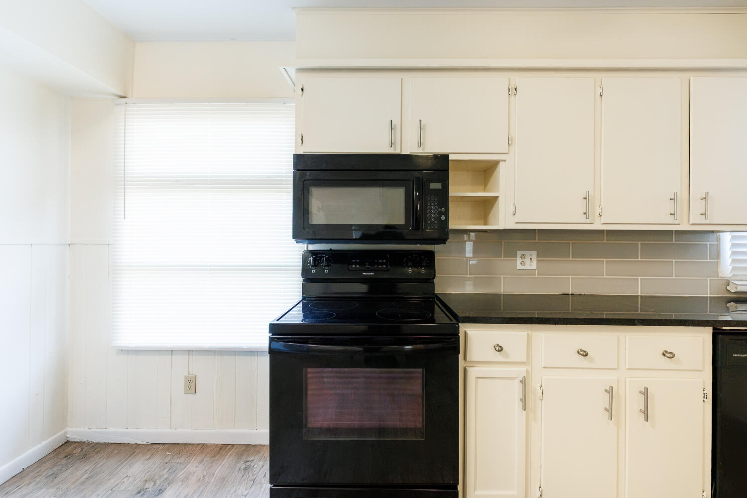 4319 40th Street Lubbock, TX 79413 - Photo 15 of 38 a kitchen with granite countertop white cabinets and black appliances