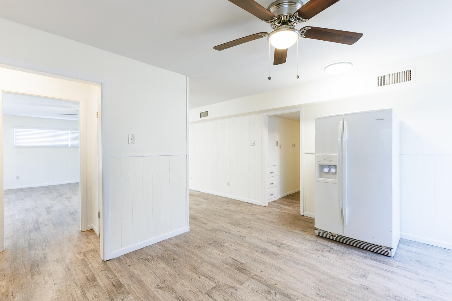 4319 40th Street Lubbock, TX 79413 - Photo 17 of 38 an empty room with wooden floor ceiling fan and refrigerator