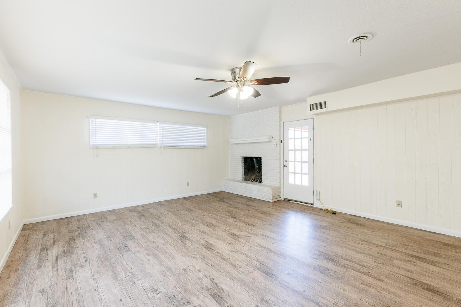 4319 40th Street Lubbock, TX 79413 - Photo 6 of 38 an empty room with wooden floor and chandelier fan