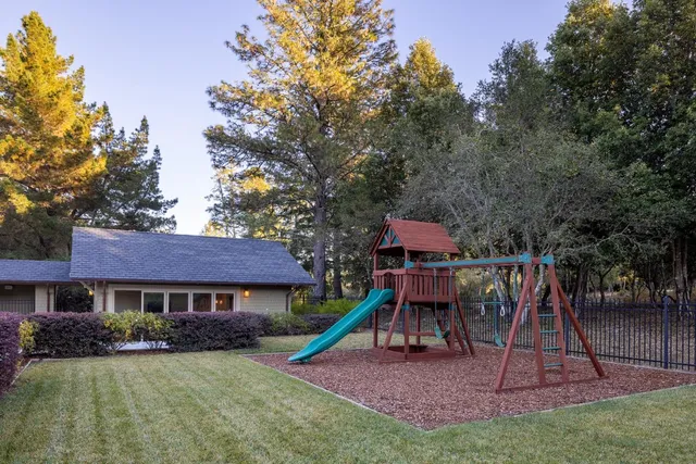 a front view of a residential houses with yard and green space
