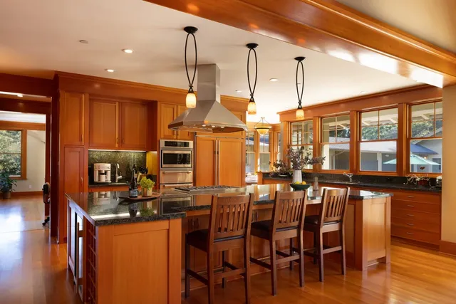 a kitchen with stainless steel appliances granite countertop a sink a stove and a wooden floors