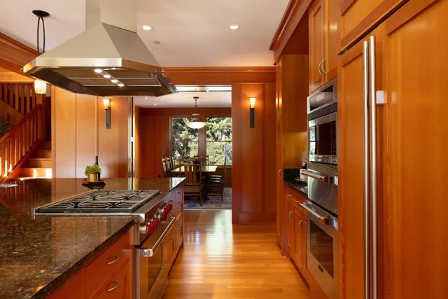 a kitchen with stainless steel appliances granite countertop a stove a sink and a wooden floors