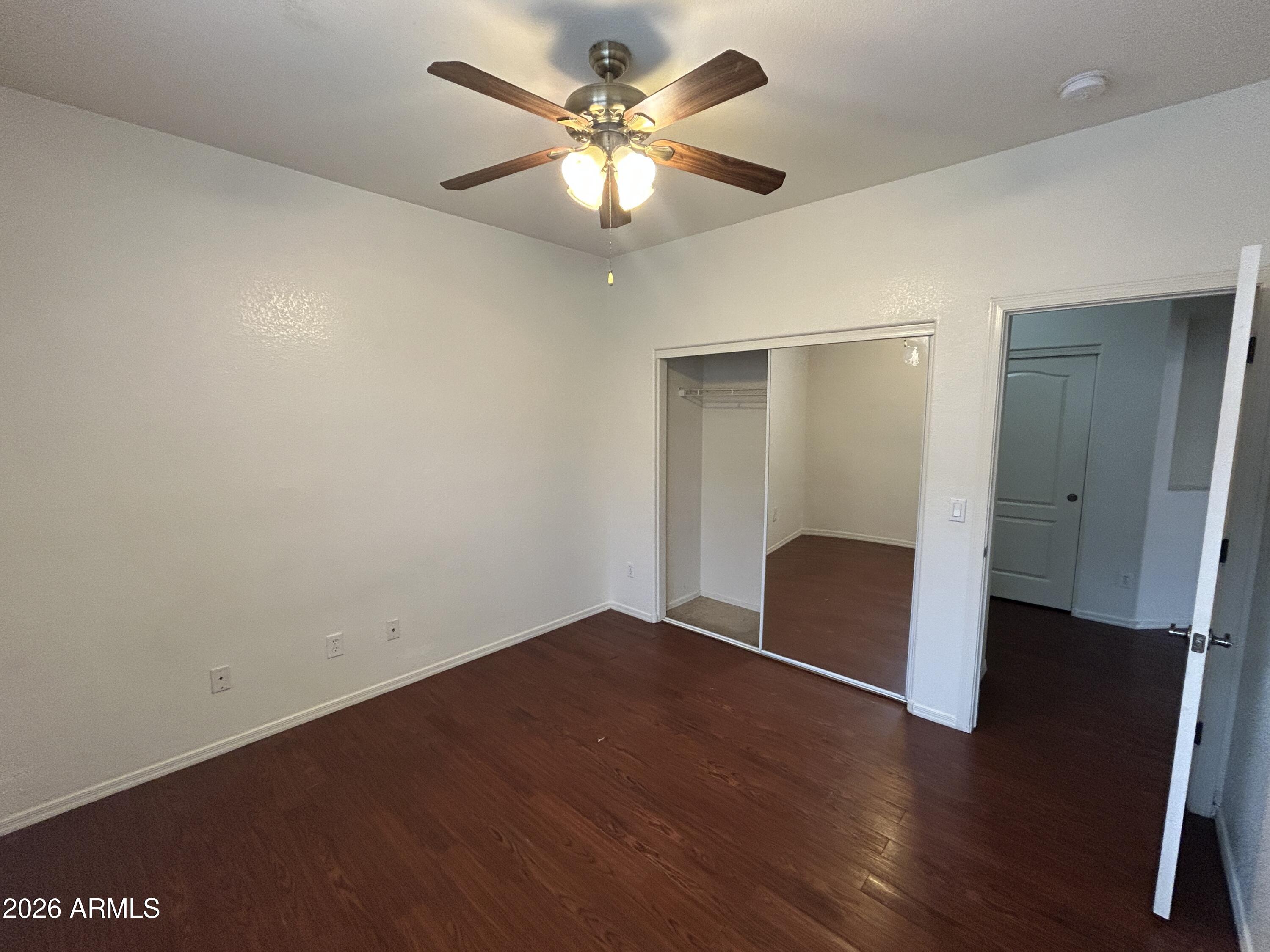 2202 West Carter Road Phoenix, AZ 85041 - Photo 13 of 20 a view of an empty room with wooden floor