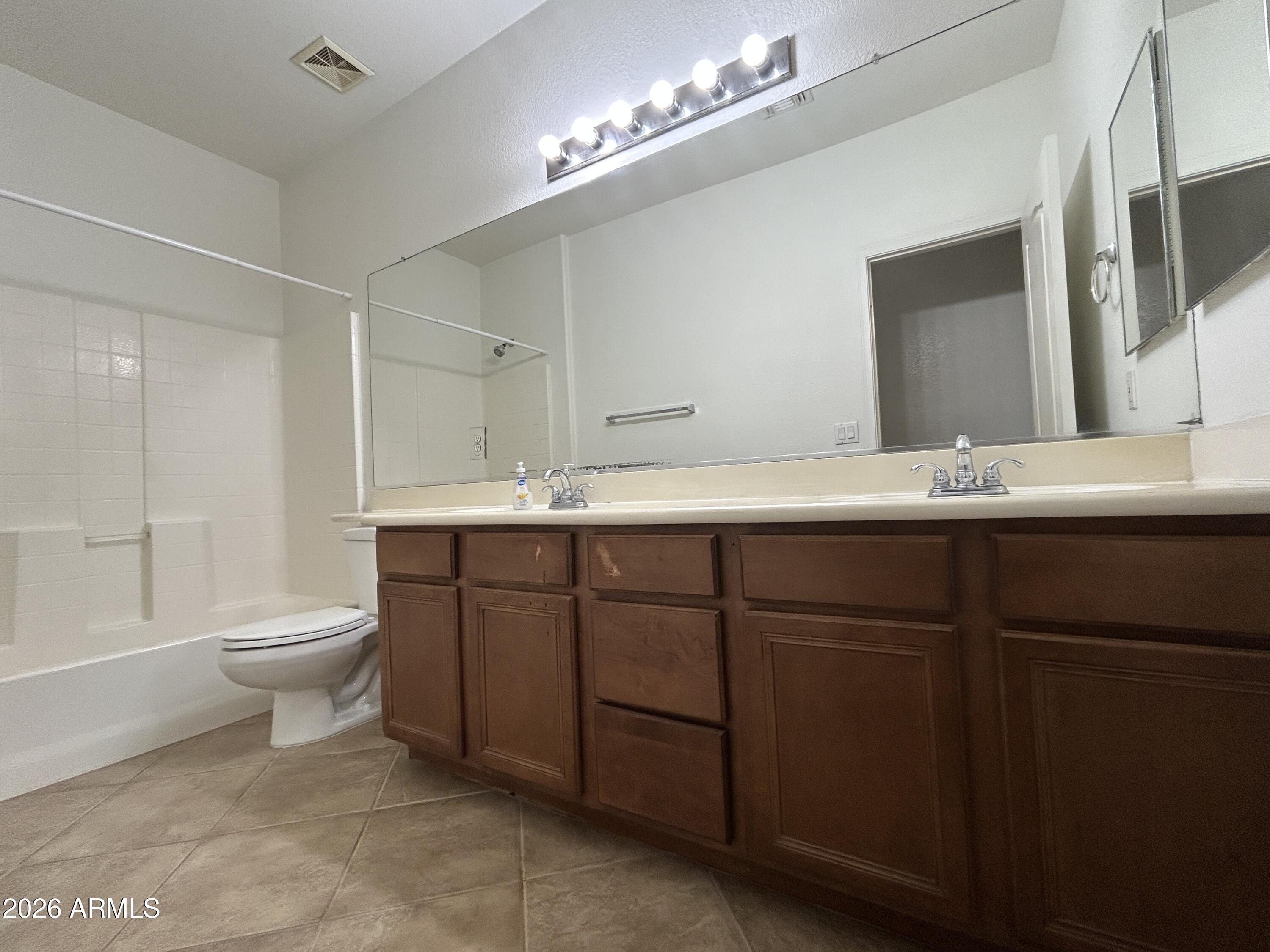 2202 West Carter Road Phoenix, AZ 85041 - Photo 7 of 20 a bathroom with a toilet sink and mirror