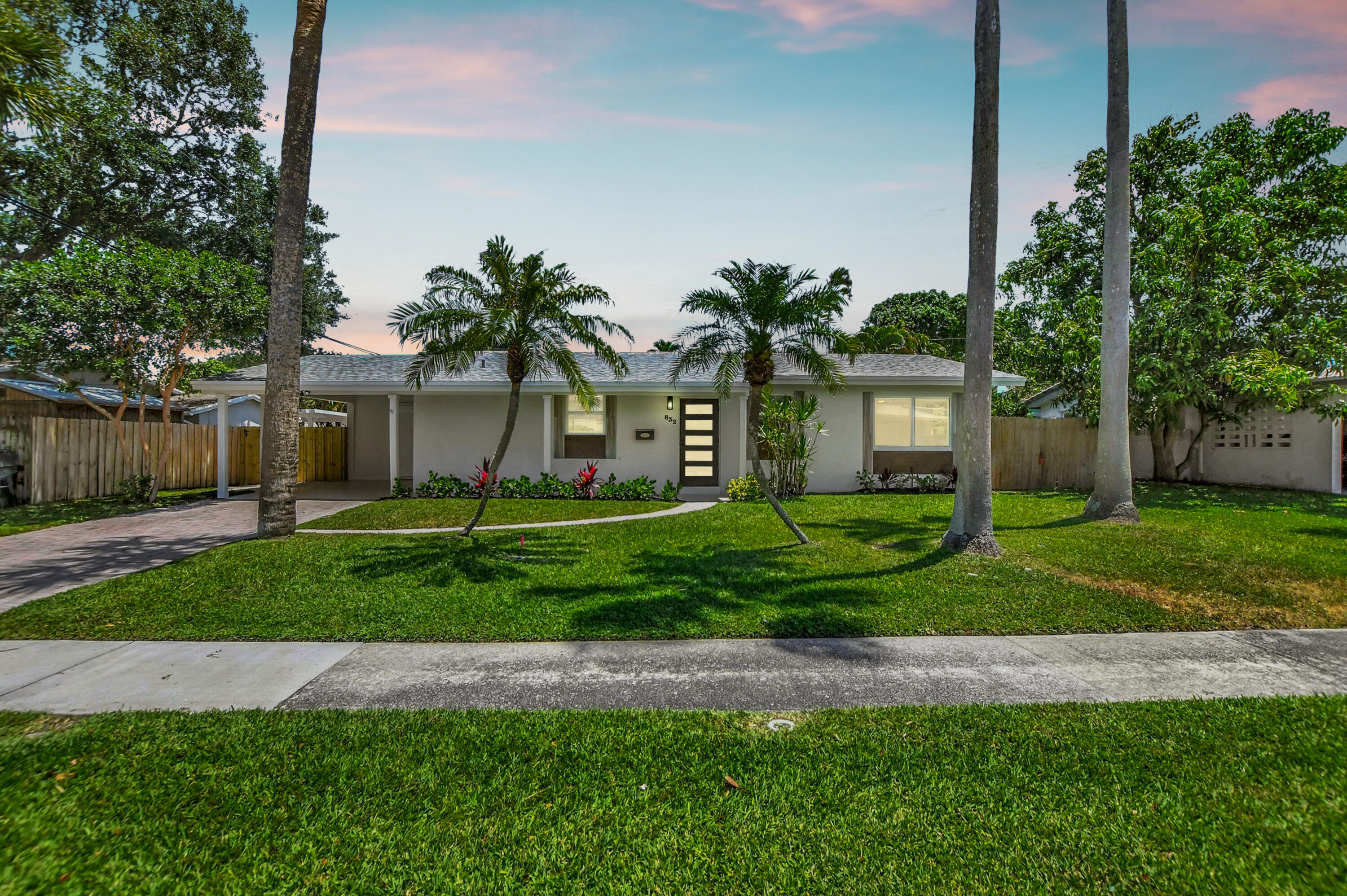 a front view of a house with a yard and potted plants