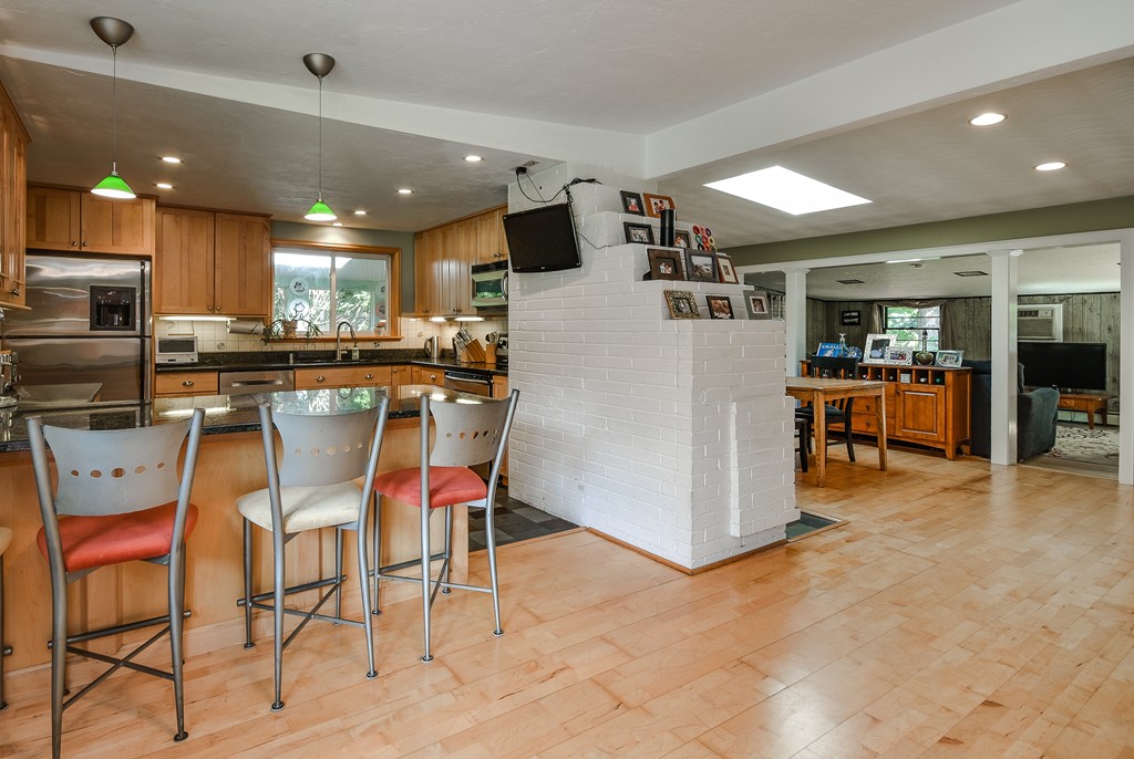 9 Ruth Drive Framingham, MA 01701 - Photo 4 of 25 a kitchen with stainless steel appliances kitchen island granite countertop a table and chairs in it