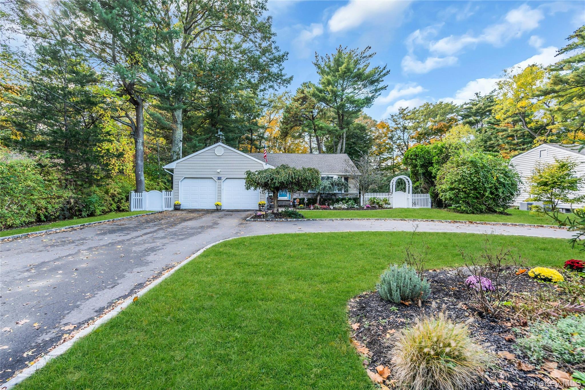 72 Mt Pleasant Road Smithtown, NY 11787 - Photo 1 of 1 Ranch-style house with view of wooded area, asphalt driveway, and an attached garage