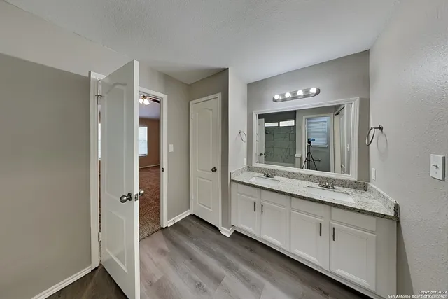 a bathroom with a granite countertop sink and a mirror