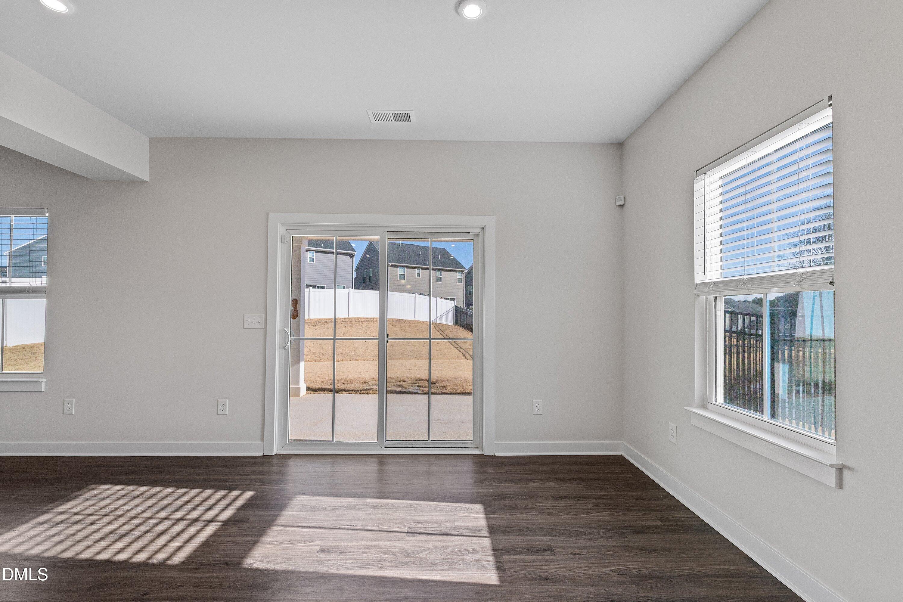 120 Misty Pike Drive Raleigh, NC 27603 - Photo 14 of 57 a view of an empty room with wooden floor and a window