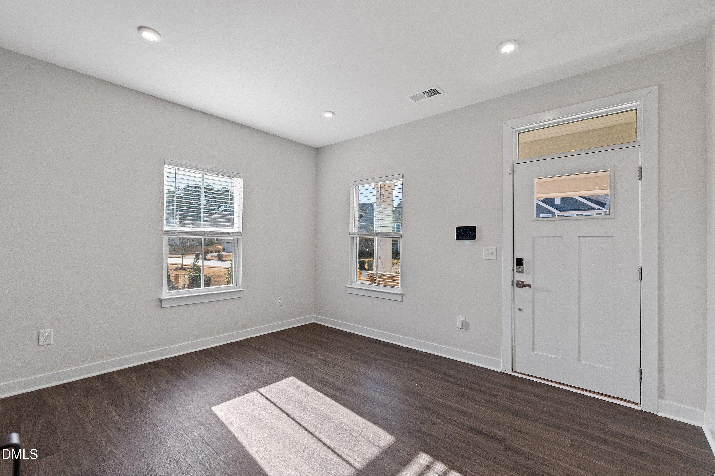 120 Misty Pike Drive Raleigh, NC 27603 - Photo 7 of 57 an empty room with wooden floor and windows