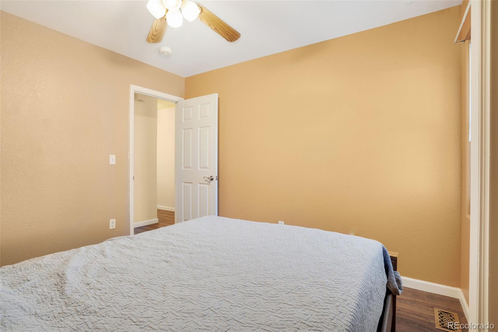 210 South Elm Street Bennett, CO 80102 - Photo 14 of 31 a bedroom with a bed and a chandelier