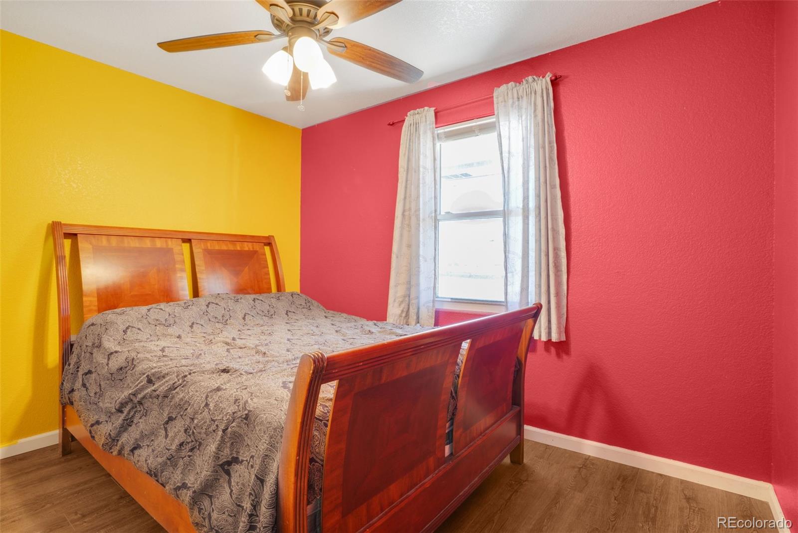 210 South Elm Street Bennett, CO 80102 - Photo 15 of 31 a bedroom with a bed and a chandelier