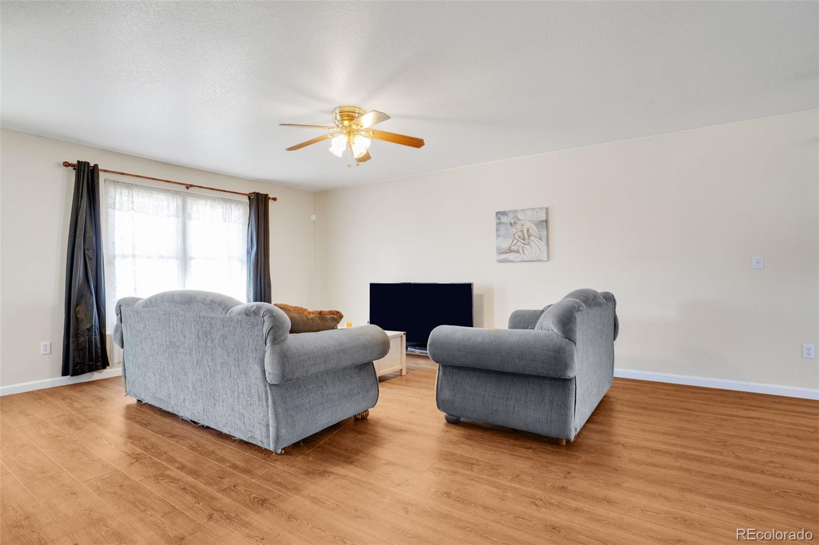 210 South Elm Street Bennett, CO 80102 - Photo 17 of 31 a living room with furniture and a fireplace