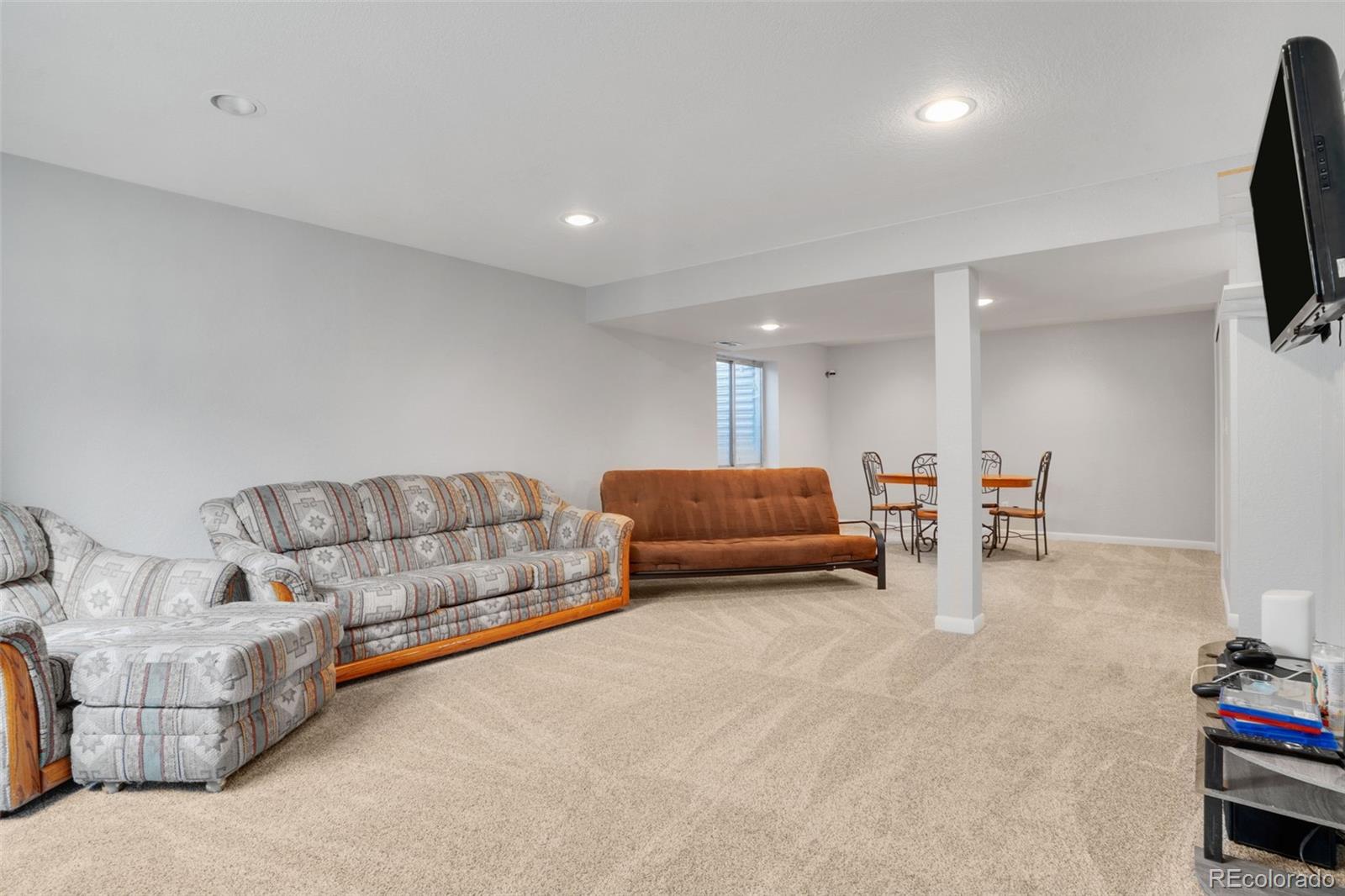 210 South Elm Street Bennett, CO 80102 - Photo 20 of 31 a living room with furniture and a flat screen tv