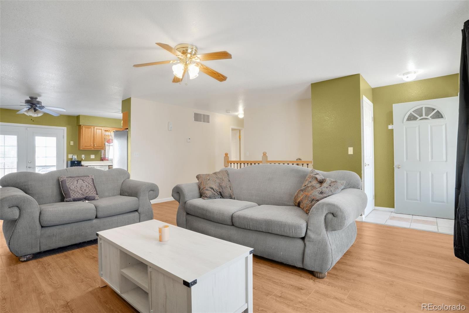 210 South Elm Street Bennett, CO 80102 - Photo 2 of 31 a living room with furniture and a chandelier