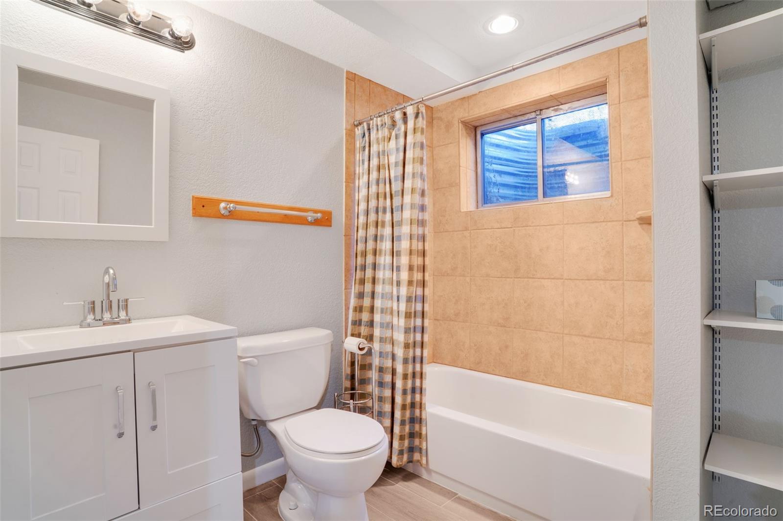 210 South Elm Street Bennett, CO 80102 - Photo 21 of 31 a bathroom with a sink toilet and shower