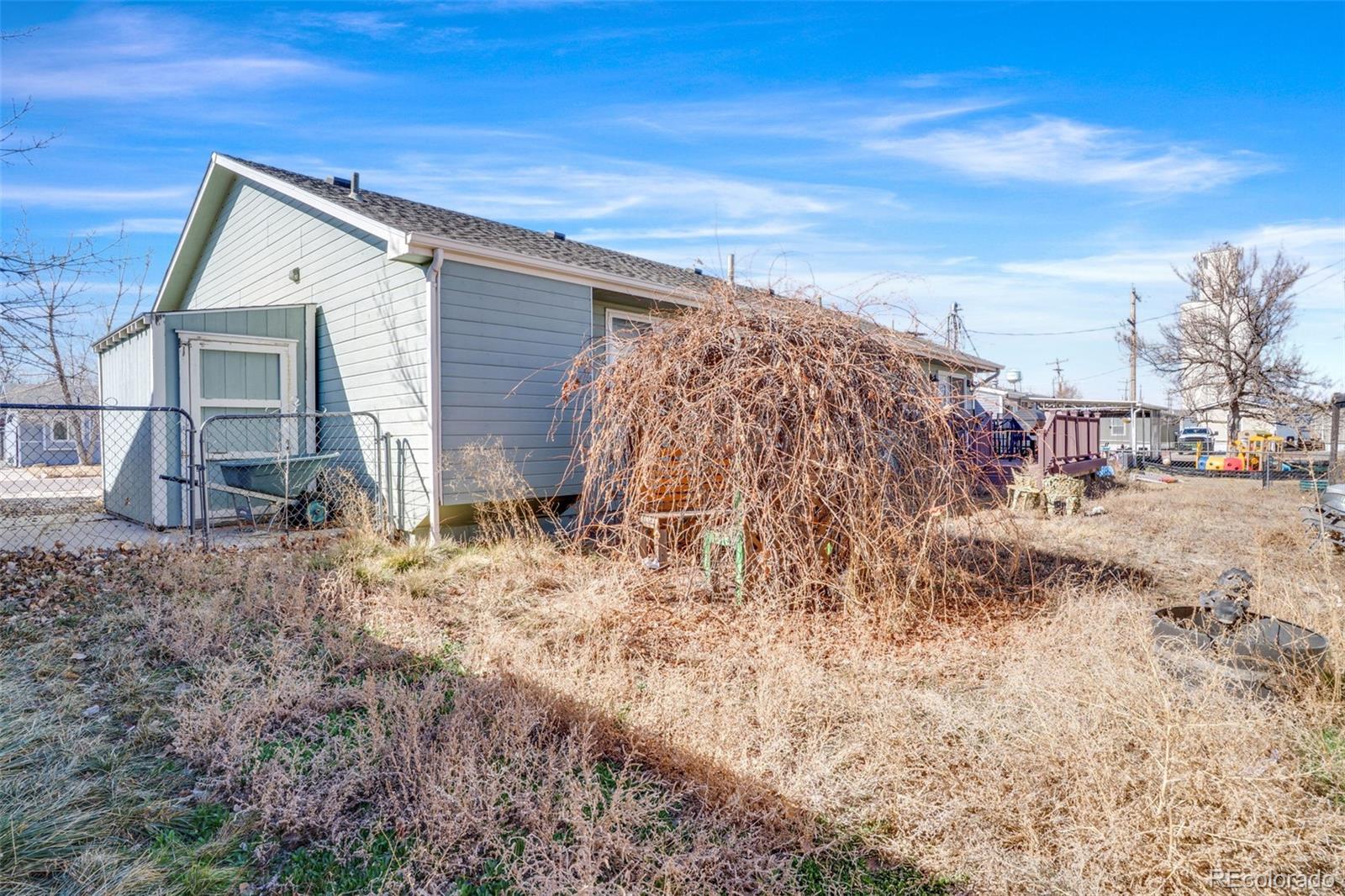 210 South Elm Street Bennett, CO 80102 - Photo 26 of 31 a view of house with backyard and trees