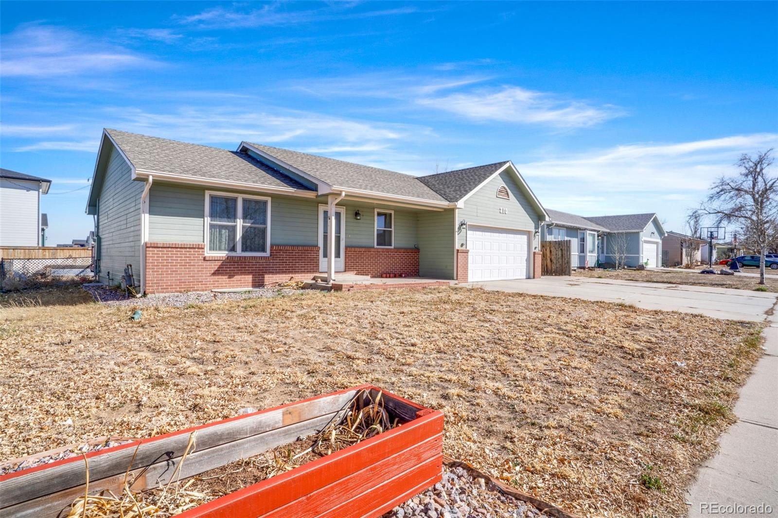 210 South Elm Street Bennett, CO 80102 - Photo 27 of 31 a front view of a house with garden