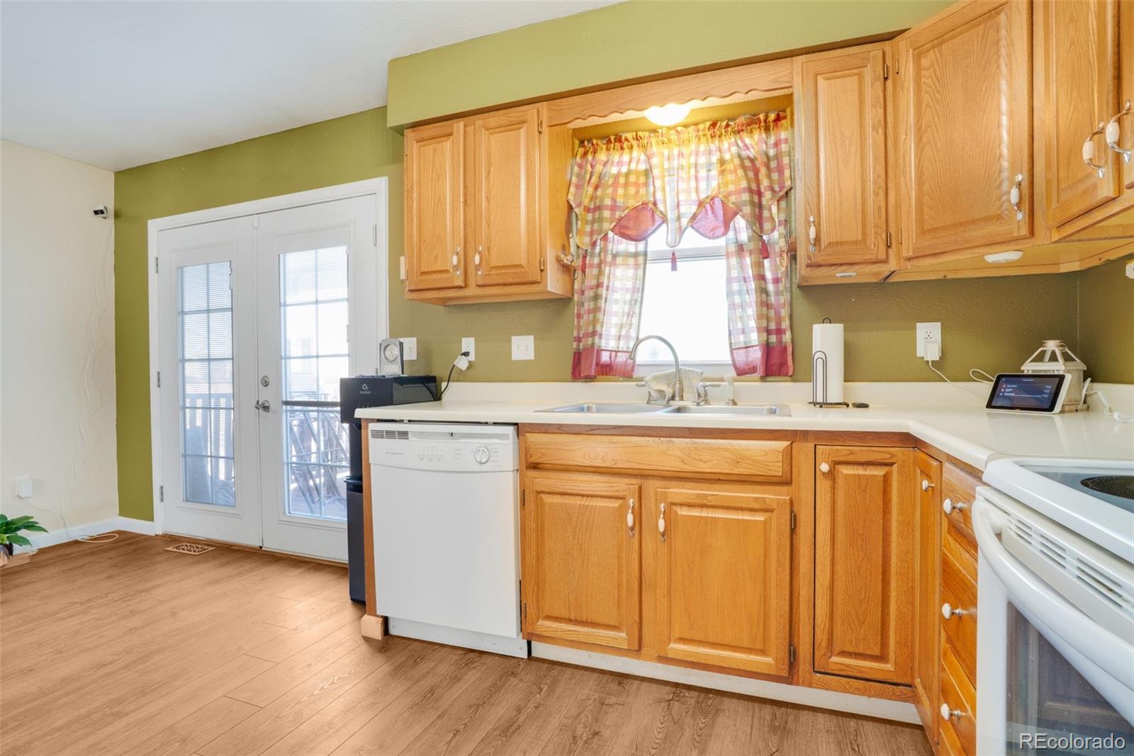 210 South Elm Street Bennett, CO 80102 - Photo 3 of 31 a kitchen with stainless steel appliances granite countertop a sink cabinets and wooden floor