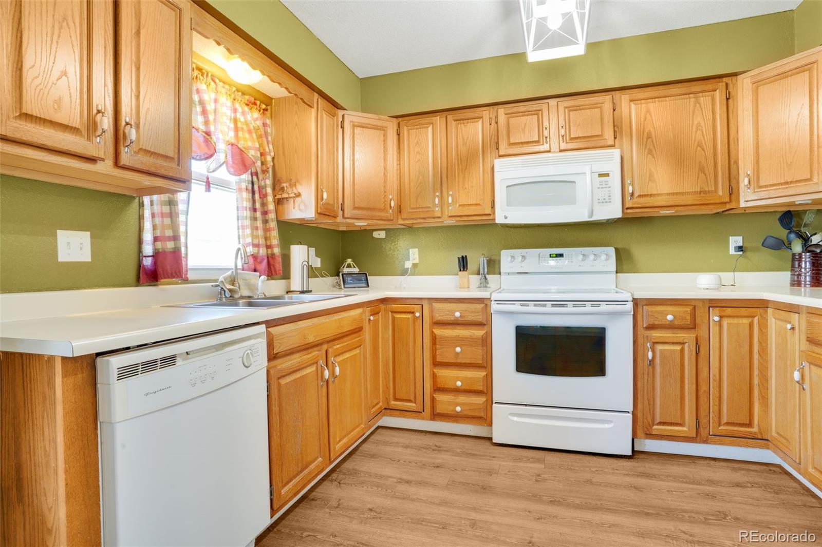 210 South Elm Street Bennett, CO 80102 - Photo 4 of 31 a kitchen with cabinets appliances a sink and a window