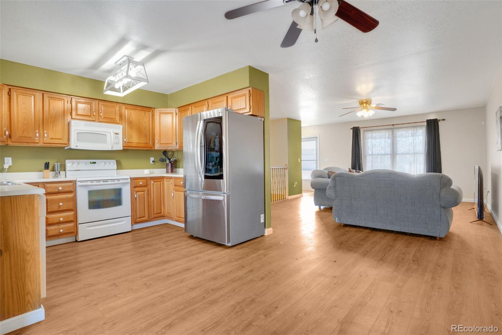 210 South Elm Street Bennett, CO 80102 - Photo 5 of 31 a kitchen with stainless steel appliances a refrigerator sink and cabinets