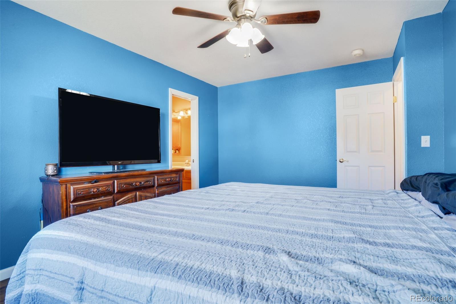 210 South Elm Street Bennett, CO 80102 - Photo 8 of 31 a bedroom with a bed and a flat screen tv