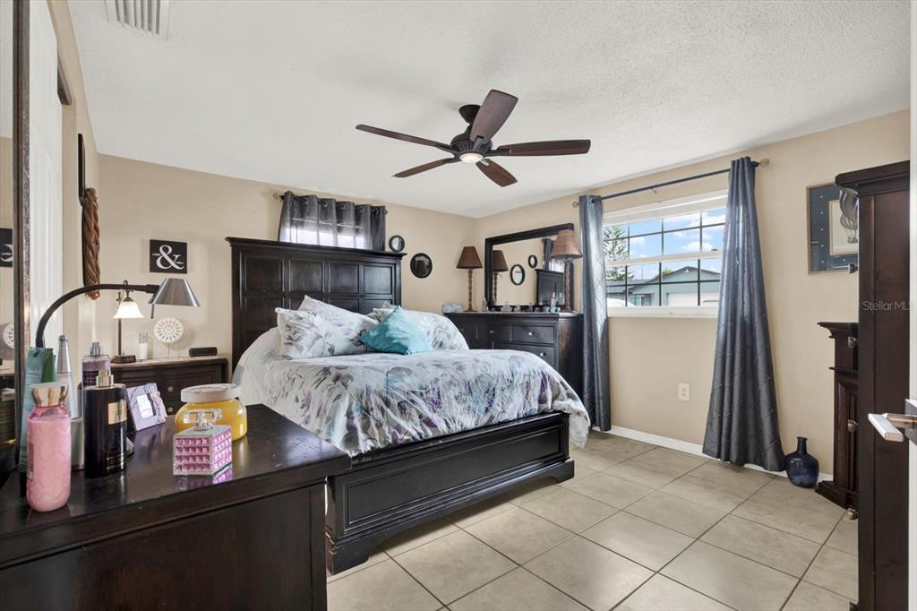 7415 Mayfield Drive Port Richey, FL 34668 - Photo 8 of 17 a bed room with a bed window and a chandelier