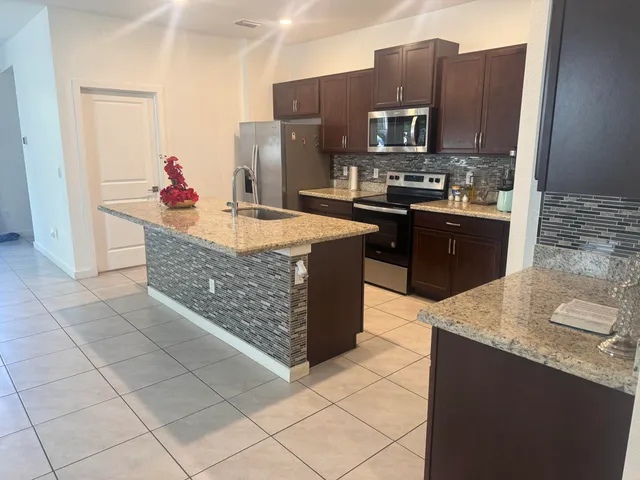 a kitchen with stainless steel appliances granite countertop a stove a sink and a microwave