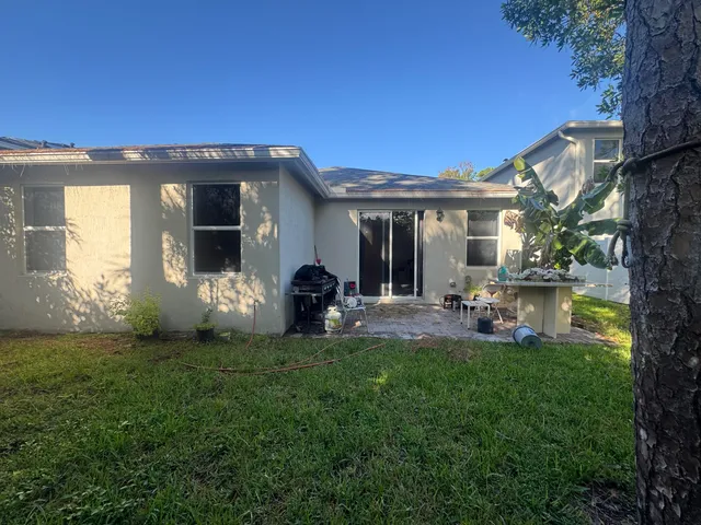 a view of a house with backyard porch and sitting area