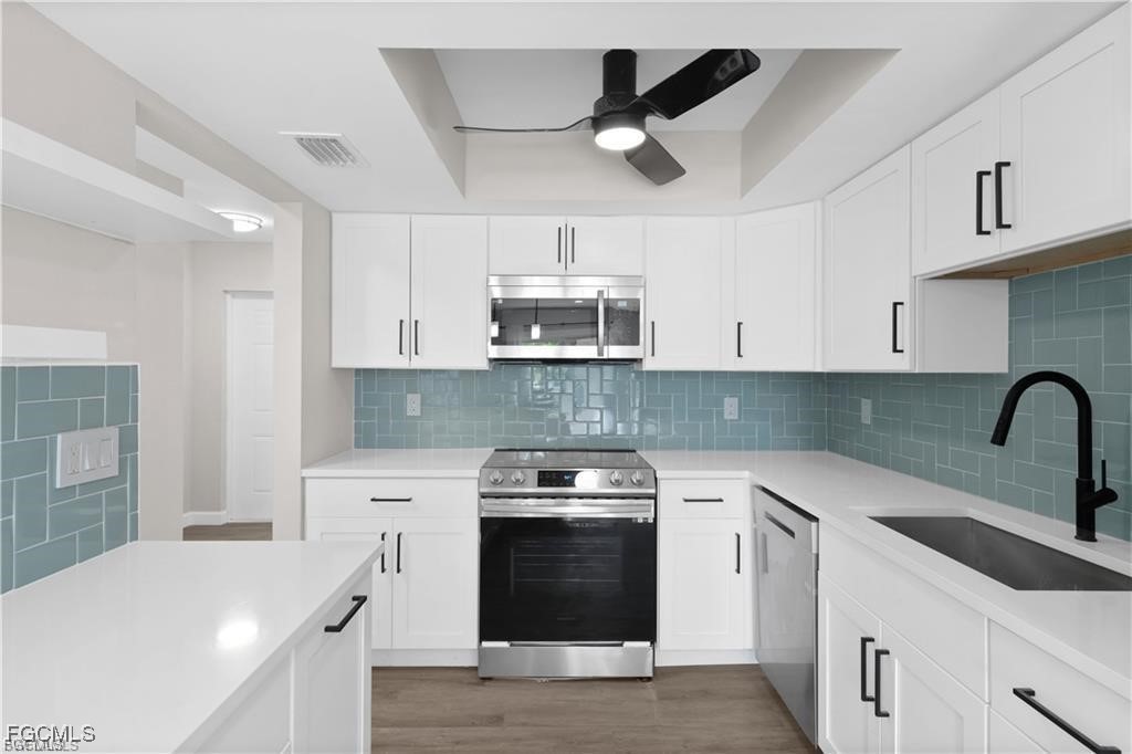 13446 Heald Lane, Unit 5B Fort Myers, FL 33908 - Photo 3 of 9 a kitchen with cabinets a sink and appliances