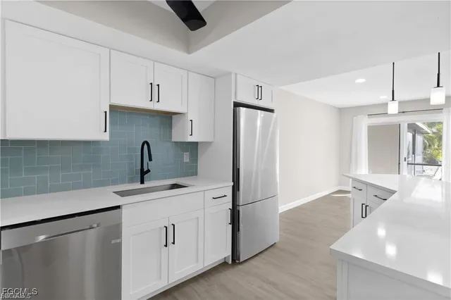a kitchen with white cabinets and sink