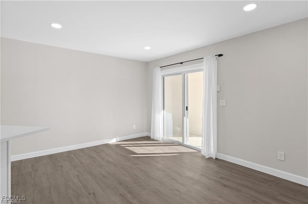 13446 Heald Lane, Unit 5B Fort Myers, FL 33908 - Photo 7 of 9 an empty room with wooden floor and windows