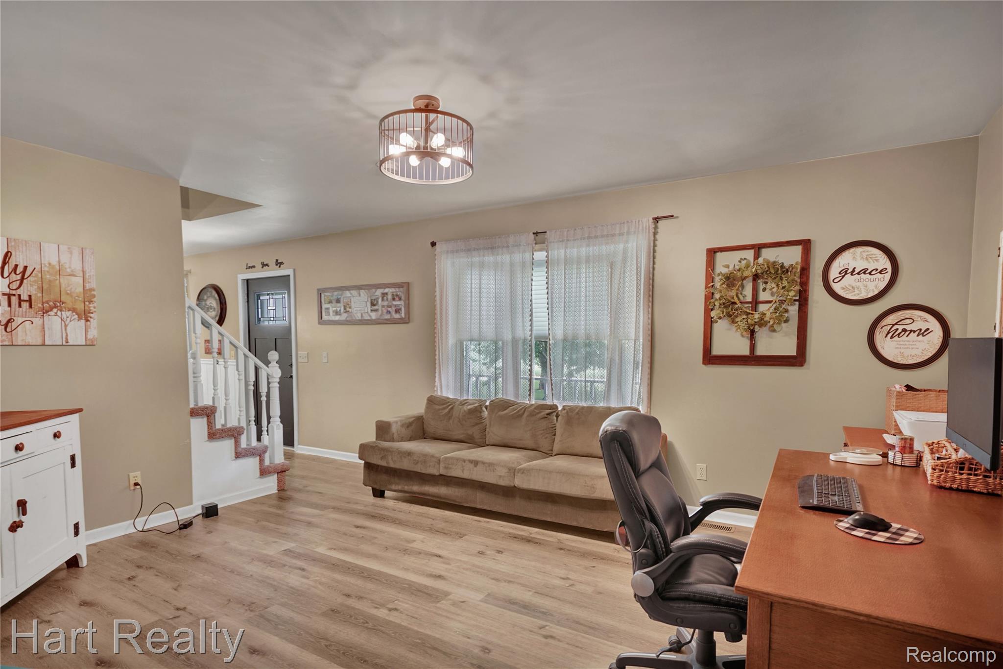 7167 Brown School Road North Branch, MI 48461 - Photo 12 of 51 Open-concept living space with wood-finish flooring, neutral wall tones, and a contemporary flush-mount ceiling light fixture