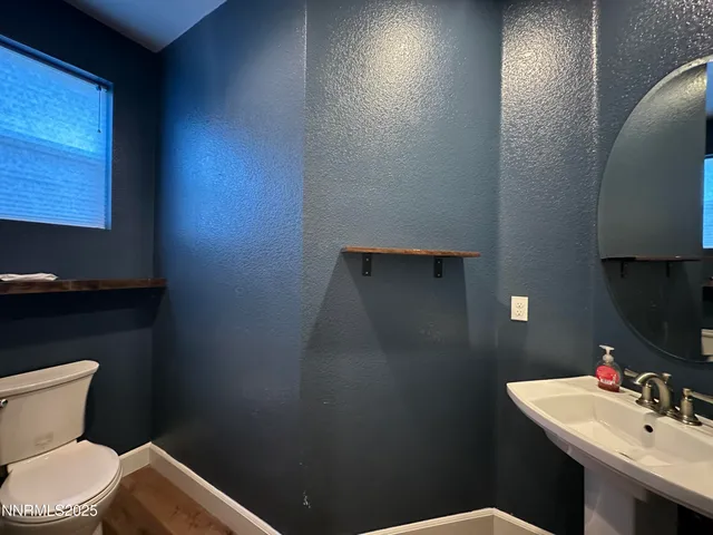 a bathroom with a toilet a sink and mirror