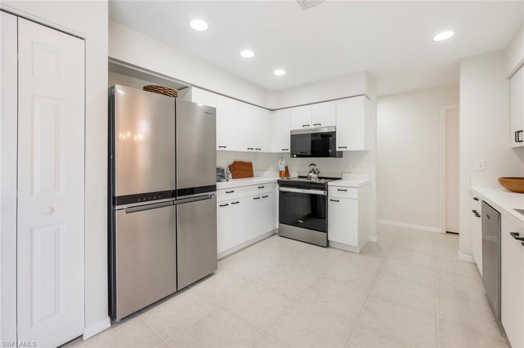 2835 Mizzen Way Naples, FL 34109 - Photo 12 of 46 a kitchen with stainless steel appliances a refrigerator sink and microwave