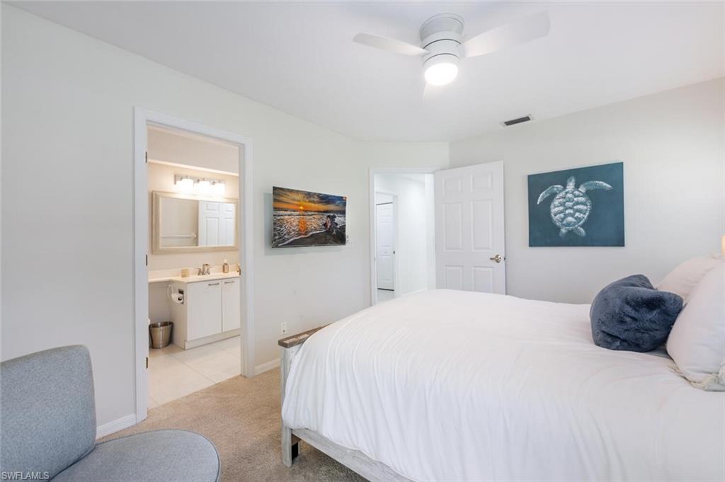 2835 Mizzen Way Naples, FL 34109 - Photo 21 of 46 a bedroom with a bed and a chandelier