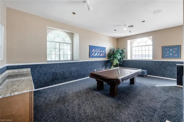 a room with pool table and windows