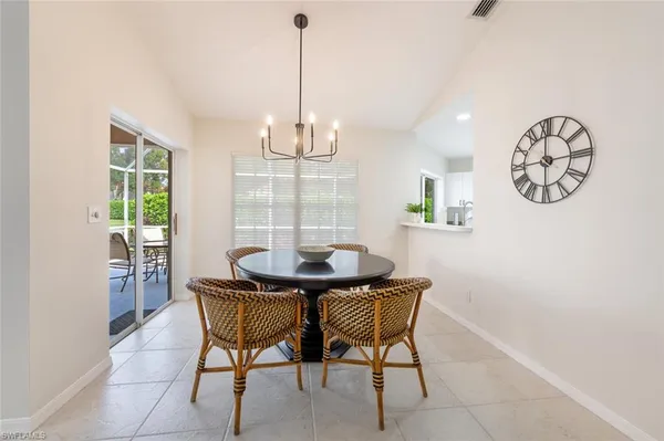 a view of a dining room and livingroom with furniture wooden floor and a chandelier
