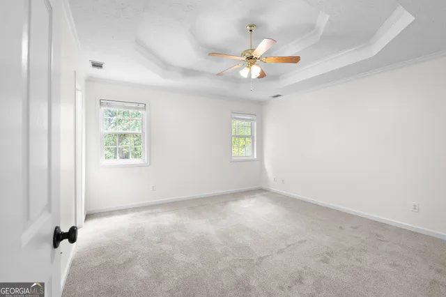 an empty room with windows and fan