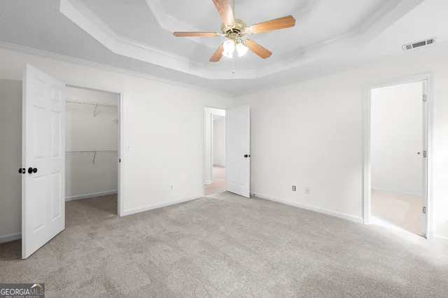 an empty room with closet and a ceiling fan