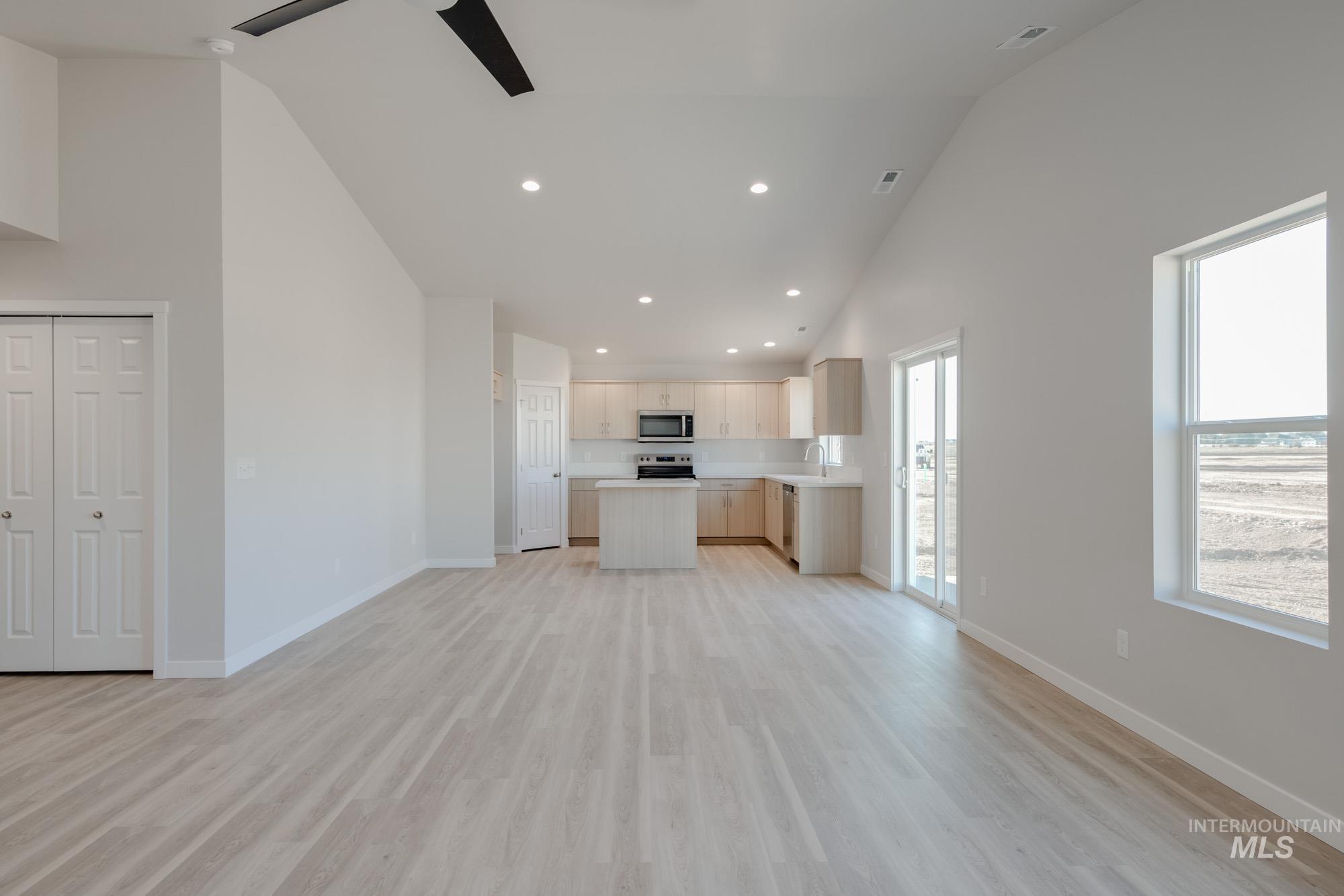 7472 South Menzingers Avenue Meridian, ID 83642 - Photo 12 of 22 Unfurnished living room featuring high vaulted ceiling, recessed lighting, light wood-style flooring, and a ceiling fan