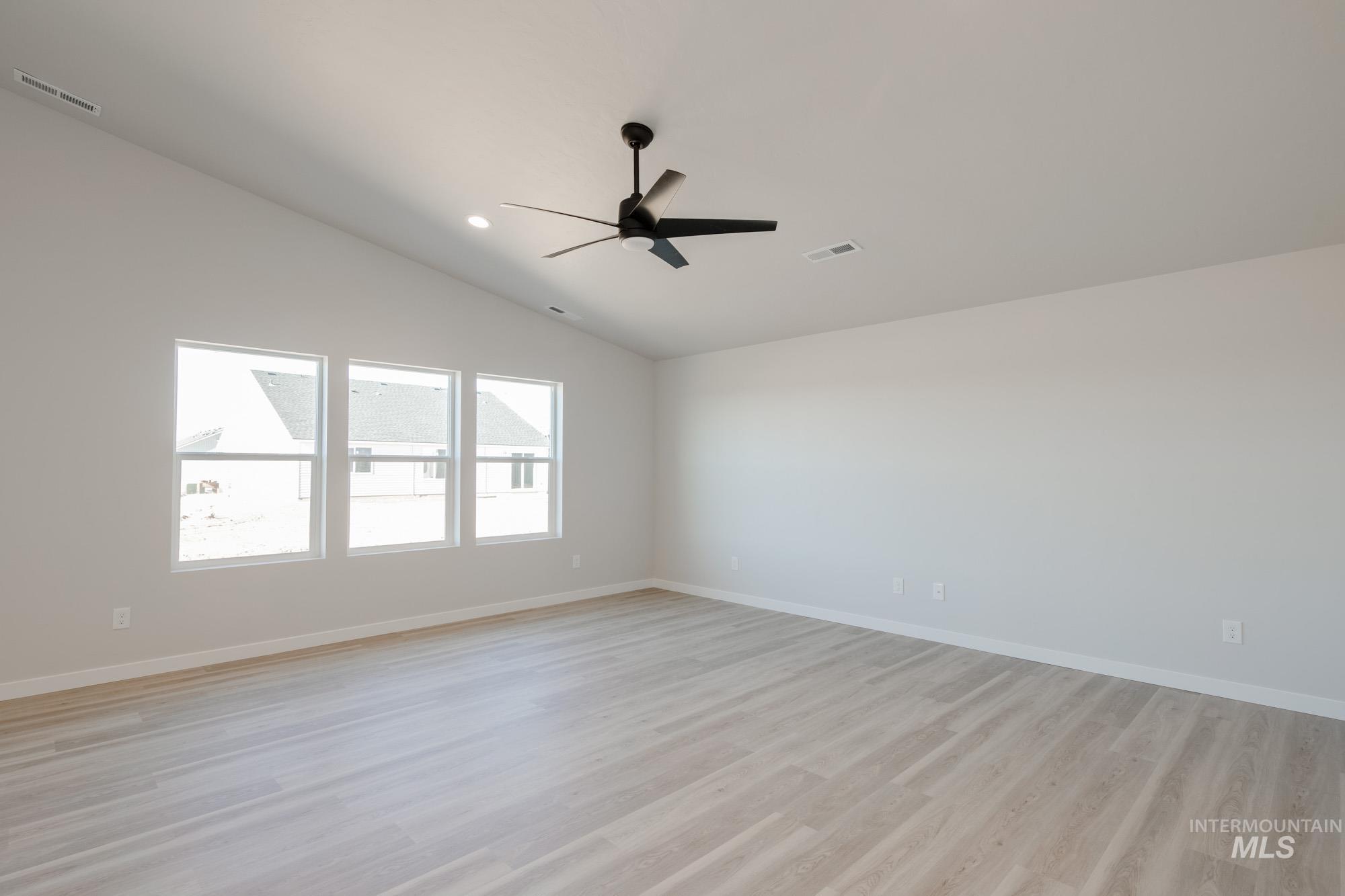 7472 South Menzingers Avenue Meridian, ID 83642 - Photo 14 of 22 Spare room featuring vaulted ceiling, light wood-style flooring, ceiling fan, and recessed lighting