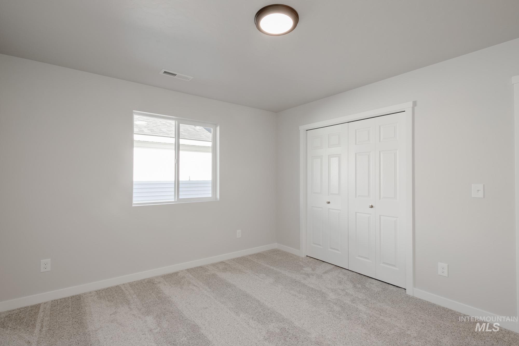 7472 South Menzingers Avenue Meridian, ID 83642 - Photo 16 of 22 Unfurnished bedroom with light colored carpet and a closet