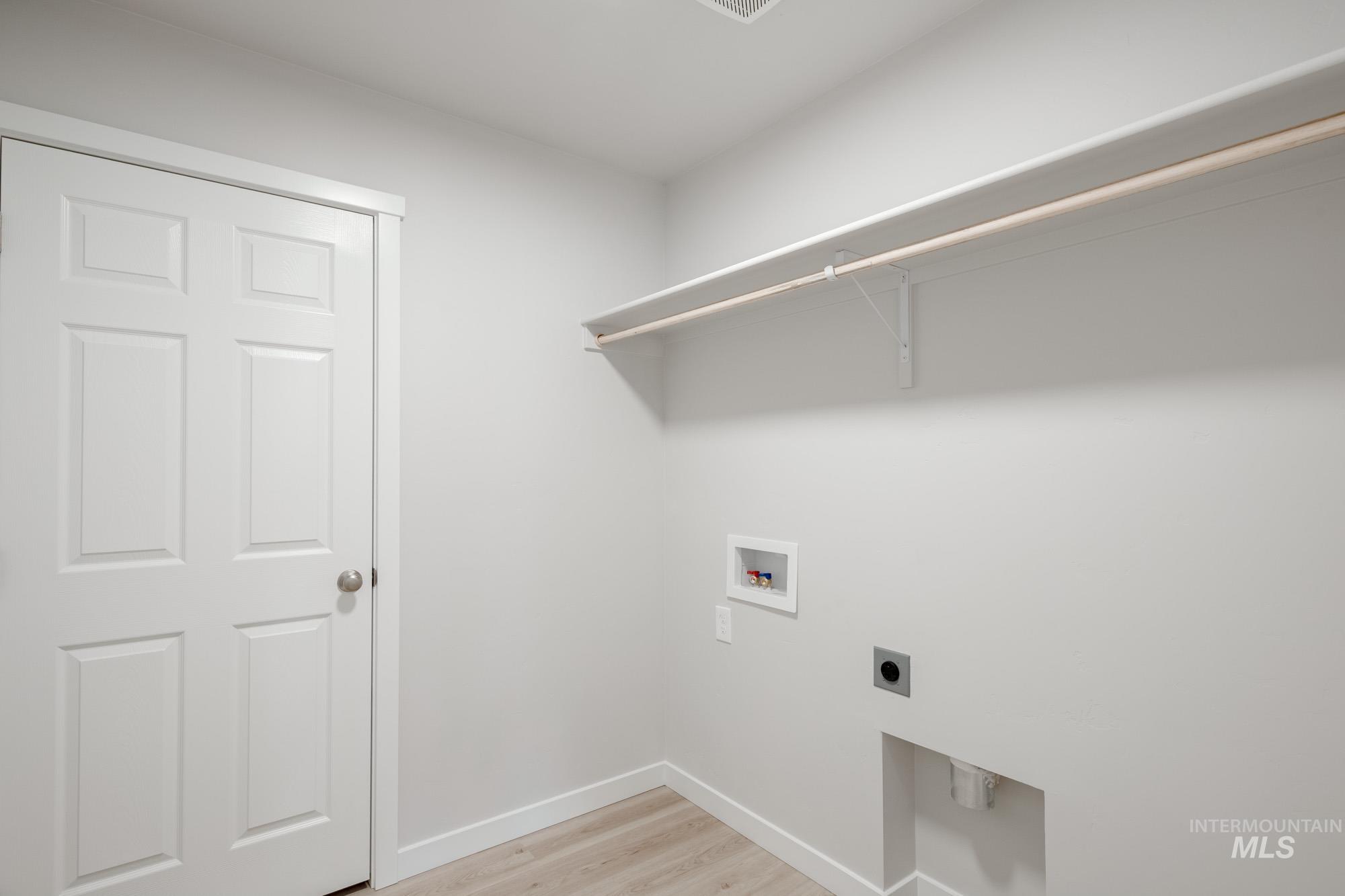 7472 South Menzingers Avenue Meridian, ID 83642 - Photo 19 of 22 Laundry area with light wood finished floors, washer hookup, and hookup for an electric dryer